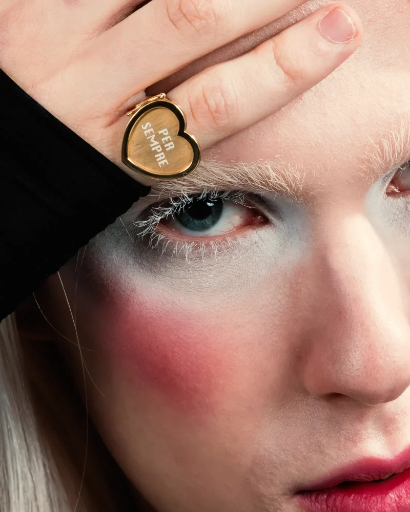 Mood-swings-PerSempre Viso di modello che indossa anello con targhetta Per sempre nel mignolo